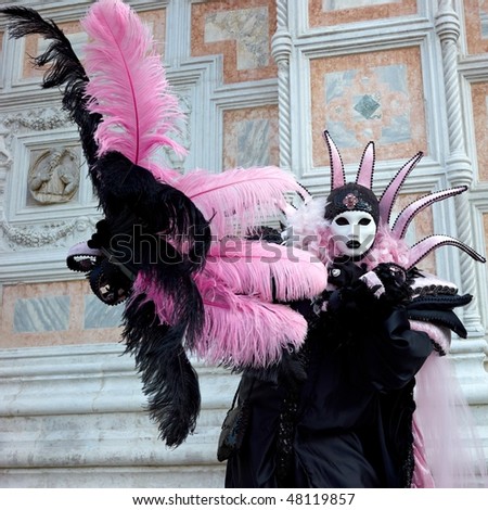 Venice carnival mask in full decorative costume. Pink and black costume.