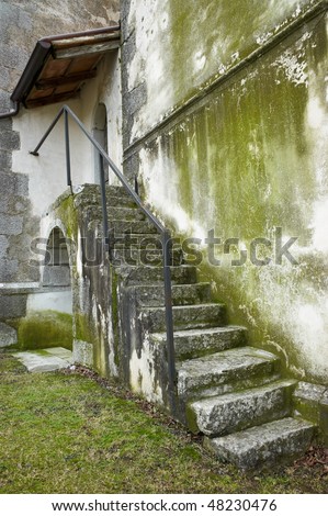Green stains made of old granite and concrete. Steps with iron enclosure.