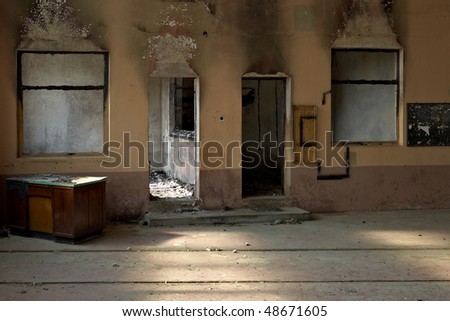 Fire damaged room. Black burnt out wood. Pastel painted walls. Dramatic light. Photo taken with Leica M9.