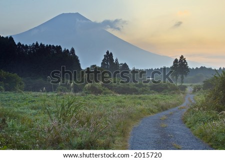 A rural country road with mount Fuji looming in the background