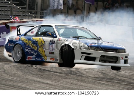 KUALA LUMPUR - MAY 20: Malaysia\'s Hanizam Hamzah (car #72) leaves a trail of smoke as he drifts in this qualifying run at the Formula Drift 2012 Asia Round 1 on May 20, 2012 in Speedcity, Malaysia.