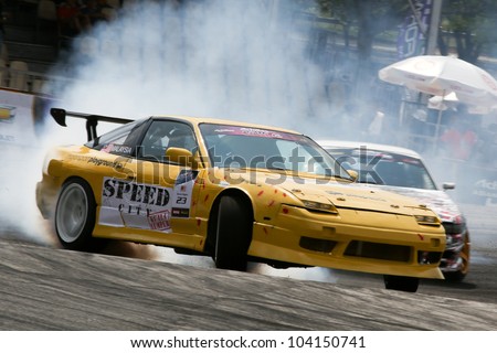 KUALA LUMPUR - MAY 20: Malaysia\'s Kevin Rajoo (car #23) leaves a trail of smoke as he drifts in this qualifying run during the Formula Drift 2012 Asia Round 1 on May 20, 2012 in Speedcity, Malaysia.