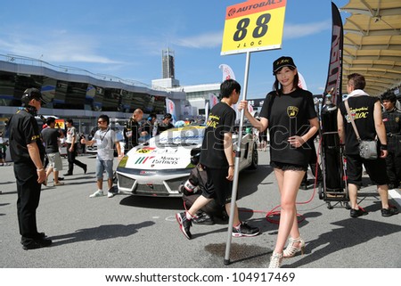 SEPANG - JUNE 10: A grid girl poses in front of a MonePa Lamborghini Gallardo car of JLOC Team at the start of the Autobacs SUPER GT Series Rd 3 on June 10, 2012 at the Sepang Int. Circuit, Malaysia.
