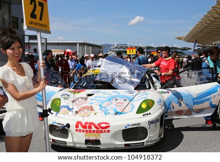 SEPANG - JUNE 10: A grid girl poses with the Ferrari F430 car of the LMP Motorsport Team on the start grid at the Autobacs SUPER GT Series Rd 3 on June 10, 2012 at the Sepang Int. Circuit, Malaysia.