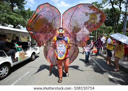 PUTRAJAYA - JULY 8: A man dressed in a colorful butterfly costume greets visitors at the entrance of the fair grounds of the annual Putrajaya Floral Festival on July 08, 2012 in Putrajaya, Malaysia.