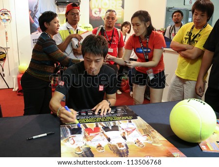 KUALA LUMPUR - SEP 22: Kei Nishikori of Japan autographs for fans in a brand promotion event of the ATP Tour Malaysian Open 2012 on September 22, 2012 at the Putra Stadium, Kuala Lumpur, Malaysia.