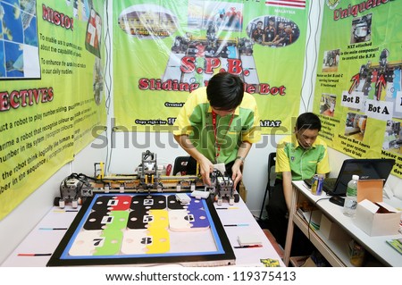 SUBANG JAYA - NOV 10: Unidentified students from Malaysia shows an intelligent robot that could identify and solve a number-puzzle at the World Robot Olympaid on Nov 10, 2012 in Subang Jaya, Malaysia.