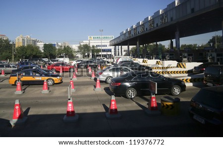 BEIJING - OCTOBER 13: Vehicles line up at the toll both of a highway on October 13, 2012 in Beijing, China. Beijing, a city of 22 million people has 5 million cars and 2,000 cars are added each month.