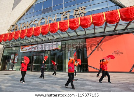BEIJING - OCTOBER 14: Elderly women practice fan dance outside a shopping mall on October 14, 2012 in Beijing, China. Healthy living is promoted here as medical and healthcare cost escalates.
