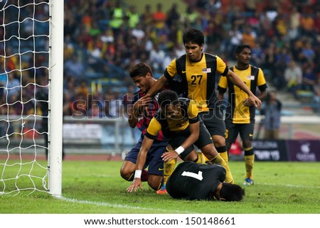 KUALA LUMPUR - AUGUST 10: Malaysia\'s defenders (yellow) and goalkeeper stops a FC Barcelona attack at the Shah Alam Stadium on August 10, 2013 in Malaysia. FC Barcelona wins 3-1.