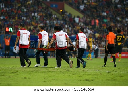 KUALA LUMPUR - AUGUST 10: Medics carry out an injured player on a stretcher in a Malaysia vs Barcelona friendly match at the Shah Alam Stadium on August 10, 2013 in Malaysia. Barcelona wins 3-1.