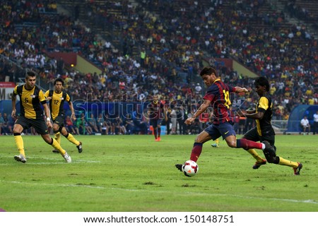 KUALA LUMPUR - AUGUST 10:FC Barcelona\'s Jonathan Santos (maroon/blue) dribbles the ball in a match vs Malaysia at the Shah Alam Stadium on Aug 10, 2013 in Kuala Lumpur, Malaysia. Barcelona wins 3-1.