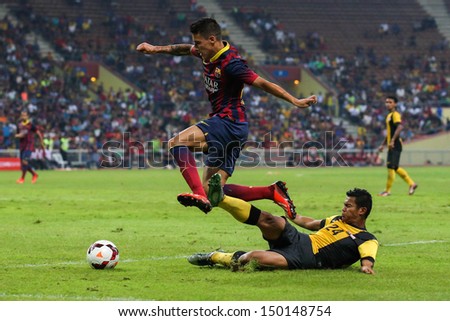 KUALA LUMPUR - AUGUST 10: FC Barcelona's Cristian Tello (maroon/blue) dribbles the ball in a match vs Malaysia at the Shah Alam Stadium on Aug 10, 2013 in Kuala Lumpur, Malaysia. Barcelona wins 3-1.