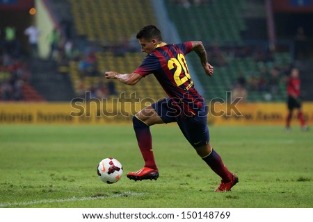 KUALA LUMPUR - AUGUST 10: FC Barcelona\'s Cristian Tello (maroon/blue) dribbles the ball in a match vs Malaysia at the Shah Alam Stadium on Aug 10, 2013 in Kuala Lumpur, Malaysia. Barcelona wins 3-1.