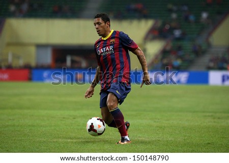 KUALA LUMPUR - AUGUST 10: FC Barcelona\'s Adriano (maroon/blue) dribbles the ball in a friendly match vs Malaysia at the Shah Alam Stadium on August 10, 2013 in Malaysia. Barcelona wins 3-1.