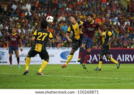 KUALA LUMPUR - AUGUST 10: Malaysia\'s Asraruddin (4) fails to stop FC Barcelona\'s Cesc Fabregas (maroon/blue) header goal at the Shah Alam Stadium on Aug 10, 2013 in Malaysia. FC Barcelona wins 3-1.