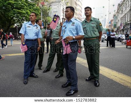 KUALA LUMPUR - AUGUST 31: Soldiers take time off to attend street celebrations during Malaysia\'s Independence Day (Hari Kemerdekaan) celebrations on August 31, 2013 in Kuala Lumpur, Malaysia.