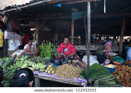 PADANG - AUGUST 25: A vendor sells fresh vegetables and other farm produce at a village market in Padang, Sumatera, Indonesia on August 25, 2013. Agriculture and fishery is an important industry here.