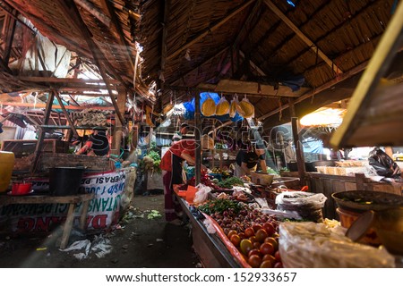 PADANG - AUGUST 25: Traders work at their stalls sell local farm produce at a village market in Padang, Sumatera, Indonesia on August 25, 2013. Agriculture and fishery is an important industry here.