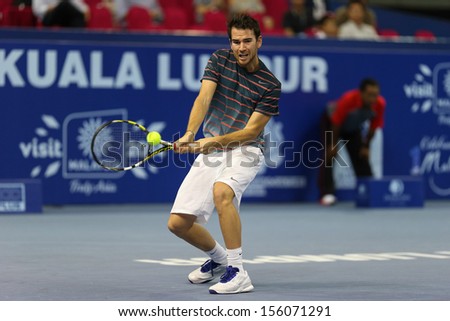 KUALA LUMPUR - SEPTEMBER 27: Adrian Mannarino volleys a return to Julien Benneteau in a semi-final match of the Malaysia Open 2013 tennis played at the Putra Stadium, Malaysia on September 27, 2013.