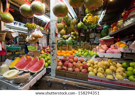 SINGAPORE - SEPTEMBER 19: A seller and customer trades at a fresh fruits stall on September 19, 2013 in Toa Payoh Market, Singapore. The traditional Asian wet market still exist in this modern city.