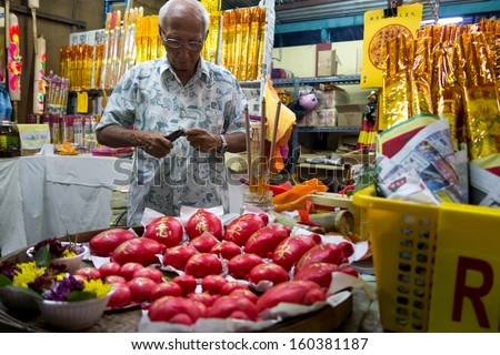 AMPANG - OCTOBER 9: A vendor sells religious prayer ornaments and paraphernalia at his stall at the Kau Ong Yah Temple in Ampang, Malaysia during the Nine Emperor Gods festival on October 9, 2013.