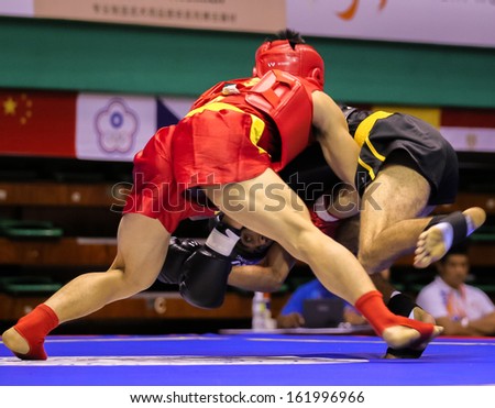 KUALA LUMPUR - NOV 03: Vietnam\'s Ban Van Trong (red) tries to take down Tunisia\'s Khalil Machraqui in the Sanda event, 12th World Wushu Championship on November 03, 2013 in Kuala Lumpur, Malaysia.