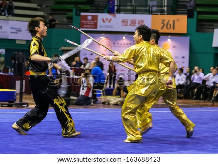 KUALA LUMPUR - NOV 05: Hong Kong\'s dalian team performs a fight scene in the Men\'s Dual Event at the 12th World Wushu Championship on November 05, 2013 in Kuala Lumpur, Malaysia.