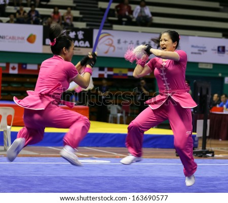 KUALA LUMPUR - NOV 05: Members of Australia\'s dalian team performs a fight scene in the Women\'s Dual Event at the 12th World Wushu Championship on November 05, 2013 in Kuala Lumpur, Malaysia.