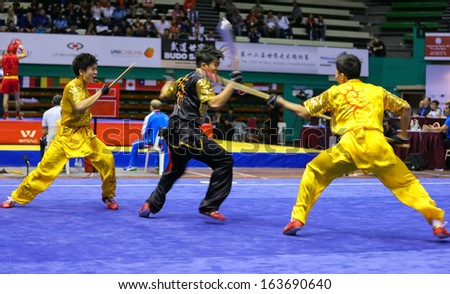 KUALA LUMPUR - NOV 05: Members of Singapore\'s dalian team performs a fight scene in the Men\'s Dual Event at the 12th World Wushu Championship on November 05, 2013 in Kuala Lumpur, Malaysia.