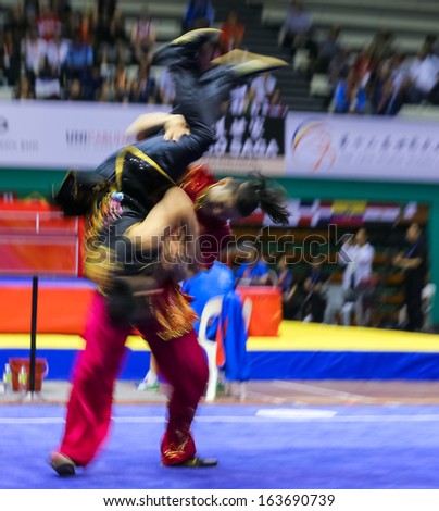 KUALA LUMPUR - NOV 05: Members of Malaysia\'s dalian team performs a fight scene in the Men\'s Dual Event at the 12th World Wushu Championship on November 05, 2013 in Kuala Lumpur, Malaysia.