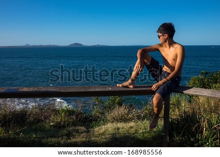 Asian boy basking in the late afternoon sun by the sea