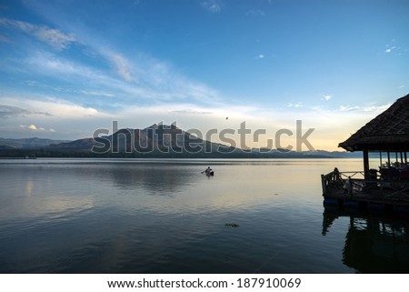 Fisherman in a boat in Lake Batur, a volcano crater lake in Bali Island, Indonesia.  The active volcano, Mount Batur is in the background.
