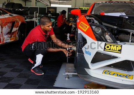 SEPANG, MALAYSIA - MAY 11, 2014: Unidentified team mechanics work on the cars for the Lamborghini Super Trofeo race, part of the Malaysian Super Series Rd 2 held at the Sepang International Circuit.