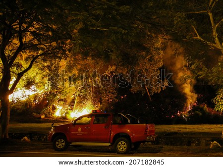 PUCHONG, MALAYSIA - JULY 26, 2014: A forest fire blazes onto the foot hills of the Air Hitam Forest Reserve in Puchong, Malaysia.  The recent dry season makes the forest susceptible to forrest fires.