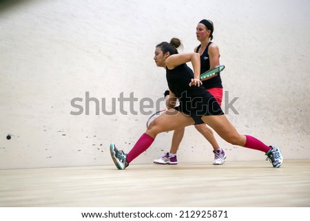 AUGUST 19, 2014 - KUALA LUMPUR, MALAYSIA: Delia Arnold of Malaysia hits a return at front court while playing Alison Waters of England (red skirt) in the CIMB Malaysian Open Squash Championship 2014.