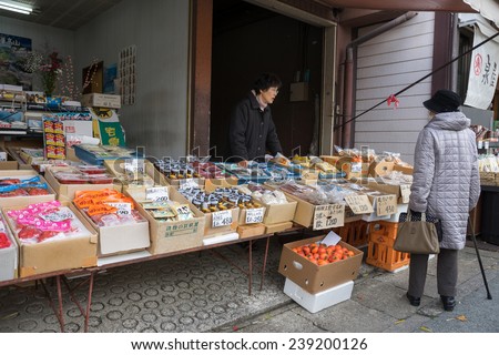 TAKAYAMA, JAPAN - DECEMBER 3, 2014: Local shopping at the Miyagawa morning market in Takayama, Japan. This morning market sells food items, groceries to farm produce and is common in rural Japan.