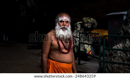 KUALA LUMPUR, MALAYSIA - JANUARY 31, 2015: A priest at the Sri Mahamarriamman temple takes a walk inside the cave temple. Hundreds of thousands of devotees gather here for the Thaipusam prayers.