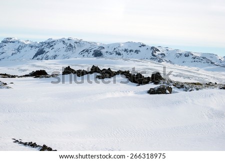 Scenic snow covered land and mountains in Iceland during winter.
