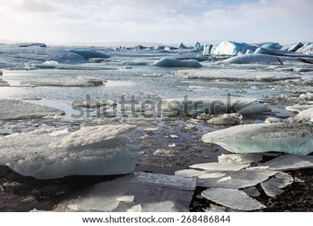 Glacier ice lagoon in Jokullsarlon, Iceland. The glacier breaks up into ice blocks in the lagoon before flowing out to sea as icebergs.