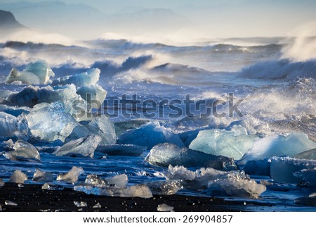 Blocks of ice from the glaciers break up and is washed ashore by the strong waves of the North Atlantic sea in Iceland.