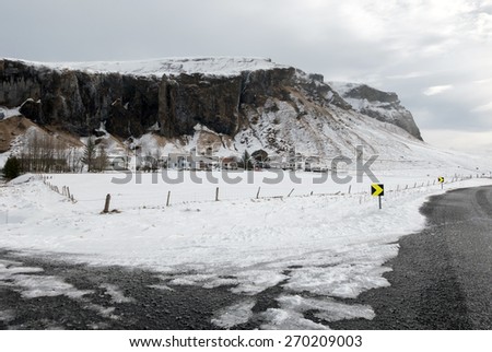 View of mountains, snow covered plains and rivers in the countryside farm lands in southern Iceland.
