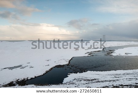 View of mountains, snow covered plains and rivers in southern Iceland during winter.