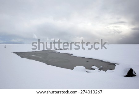 View of mountains, snow covered plains and rivers in southern Iceland during winter.