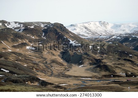 View of snow covered mountains and grass plains in southern Iceland during winter.