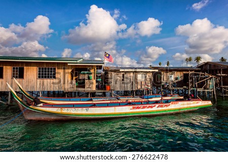 SABAH, MALAYSIA - SEPT 11: Sea gypsy boats moor besides the owners\' wooden houses on Mabul Island, Sabah. Sea gypsies had lived in homes built on stilts planted into the seabeds for centuries.