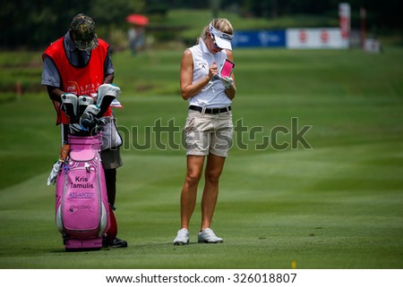 KUALA LUMPUR, MALAYSIA - OCTOBER 09, 2015: USA\'s Kris Tamulis takes down notes on the sixth hole fairway of the KL Golf & Country Club at the 2015 Sime Darby LPGA Malaysia golf tournament.