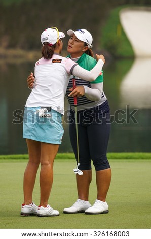 KUALA LUMPUR, MALAYSIA - OCTOBER 10, 2015: Amy Yang (black pants) hugs Chella Choi at the end of Round 3 of the 2015 Sime Darby LPGA Malaysia golf tournament played at the KL Golf & Country Club.