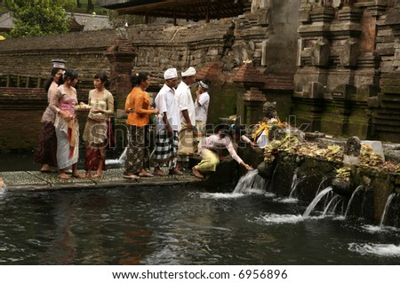 devotees at cleansing and purification pool in Bali temple