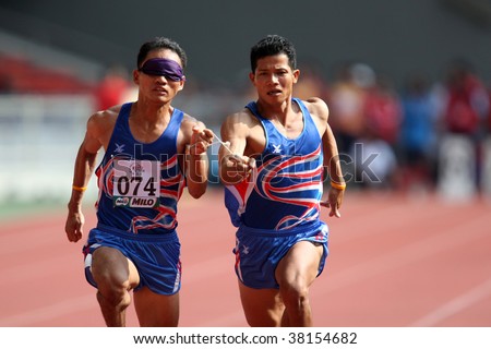 KUALA LUMPUR - AUGUST 15: Thailand\'s blind athlete Kitsana Jorchuy runs with a guide at the track and field event of the fifth ASEAN Para Games on August 15, 2009 in Kuala Lumpur.